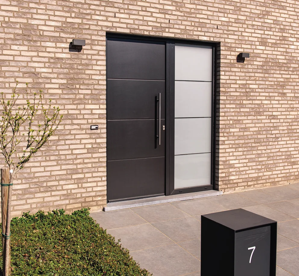 Porte d'entrée panneau Frager Mondial MO171 Plato noir et blanc sur façade en brique claire