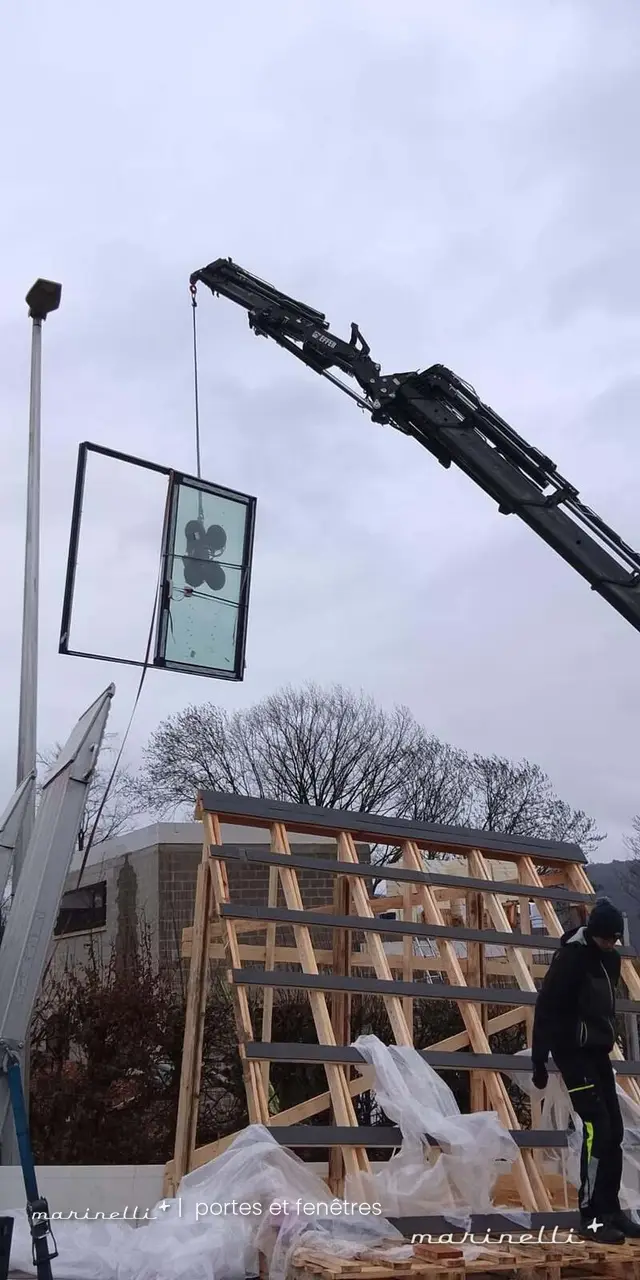 Levage d'un vitrage au camion-grue sur chantier